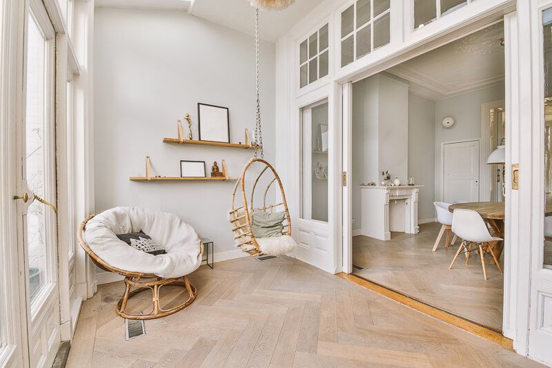 Interior design photography in Washington DC capturing a sleek minimalist living space with bold contrast elements, dark feature wall with fireplace, modern gray seating, and polished wood flooring with contemporary art accents.